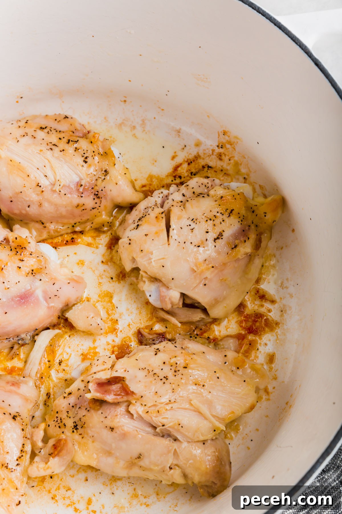 Roasted Chicken and Poblano Soup Recipe 6 A close up of chicken thighs cooking in a white dutch oven.