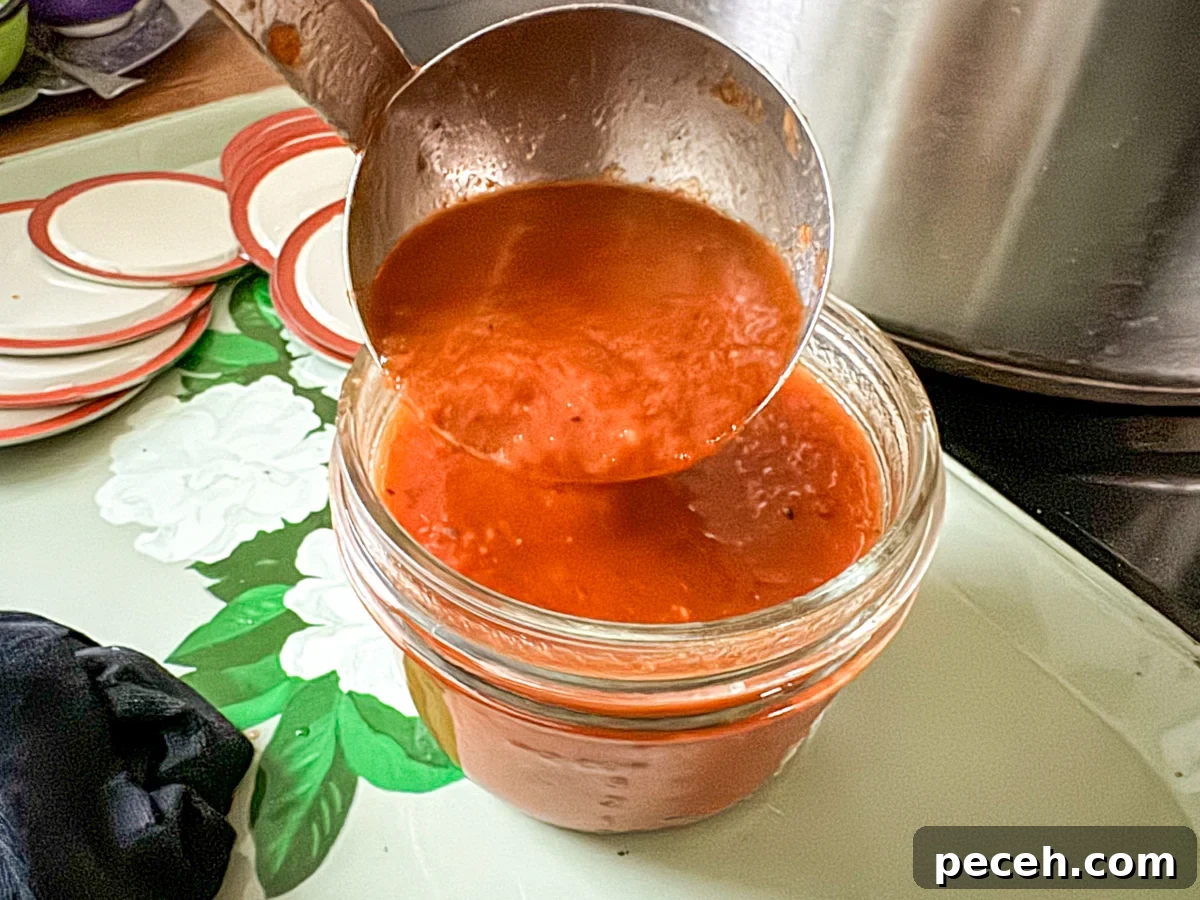 Canned Pizza Sauce Recipe Using Fresh or Frozen Tomatoes 8 Adding pizza sauce to canning jar