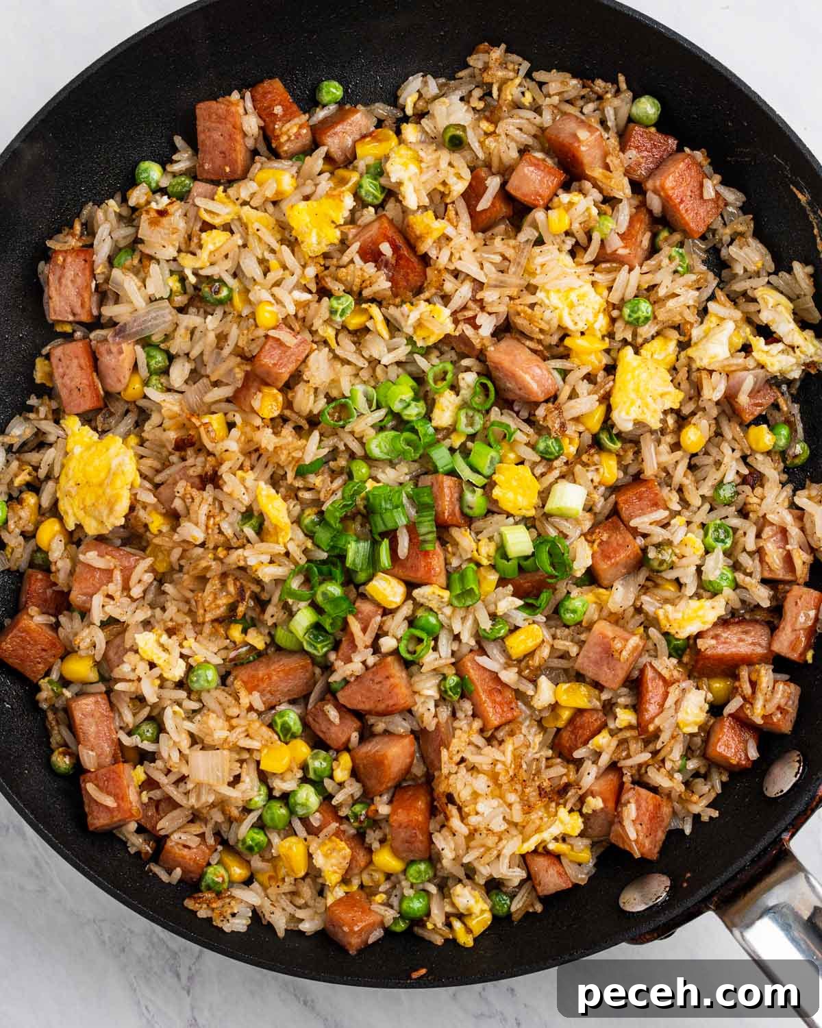 Crispy SPAM Fried Rice Recipe for Quick Weeknight Meals 2 Spam fried rice in a nonstick pan garnished with green onions.