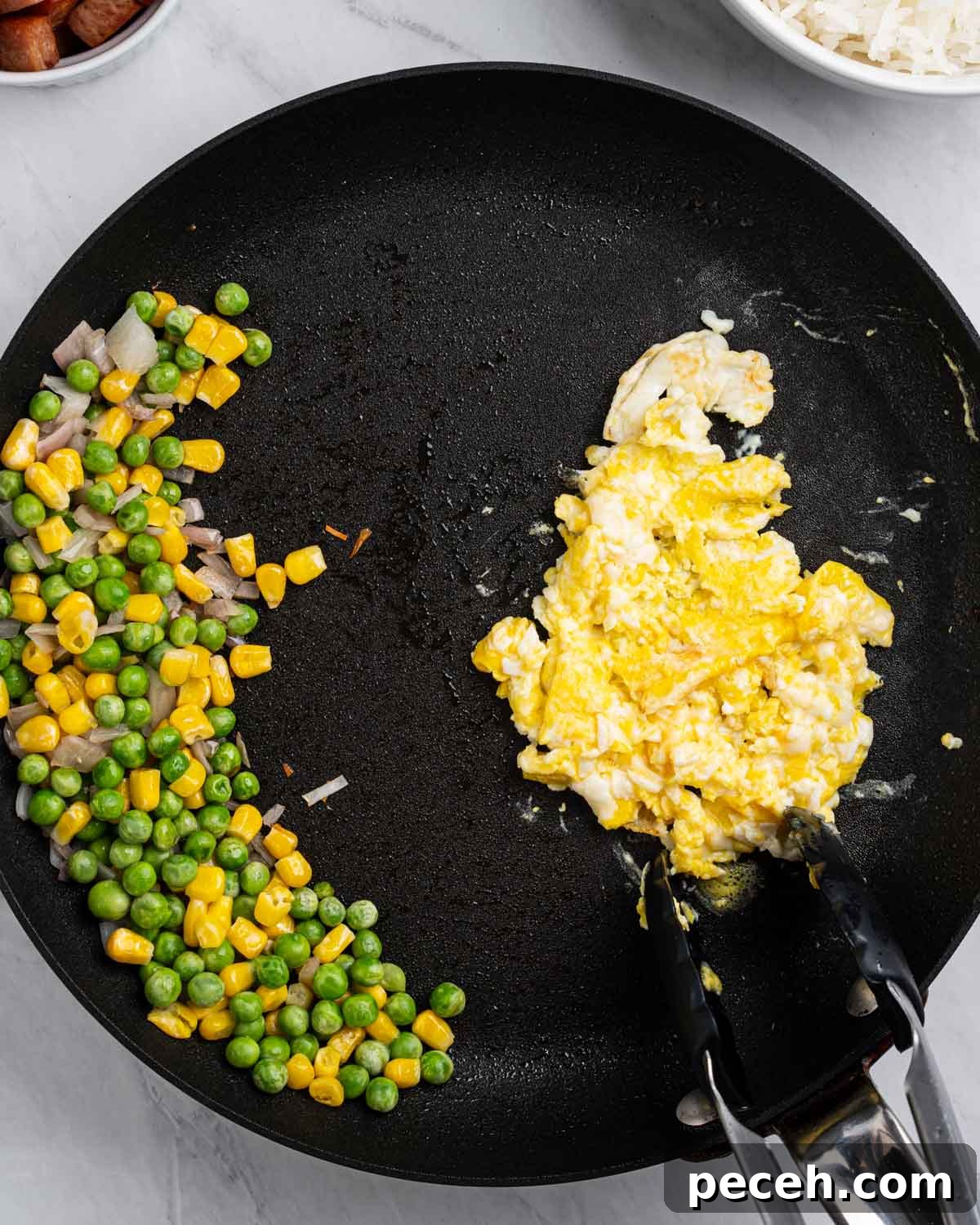 Crispy SPAM Fried Rice Recipe for Quick Weeknight Meals 7 Pan with vegetables scoot to on side and eggs scrambled on the other.