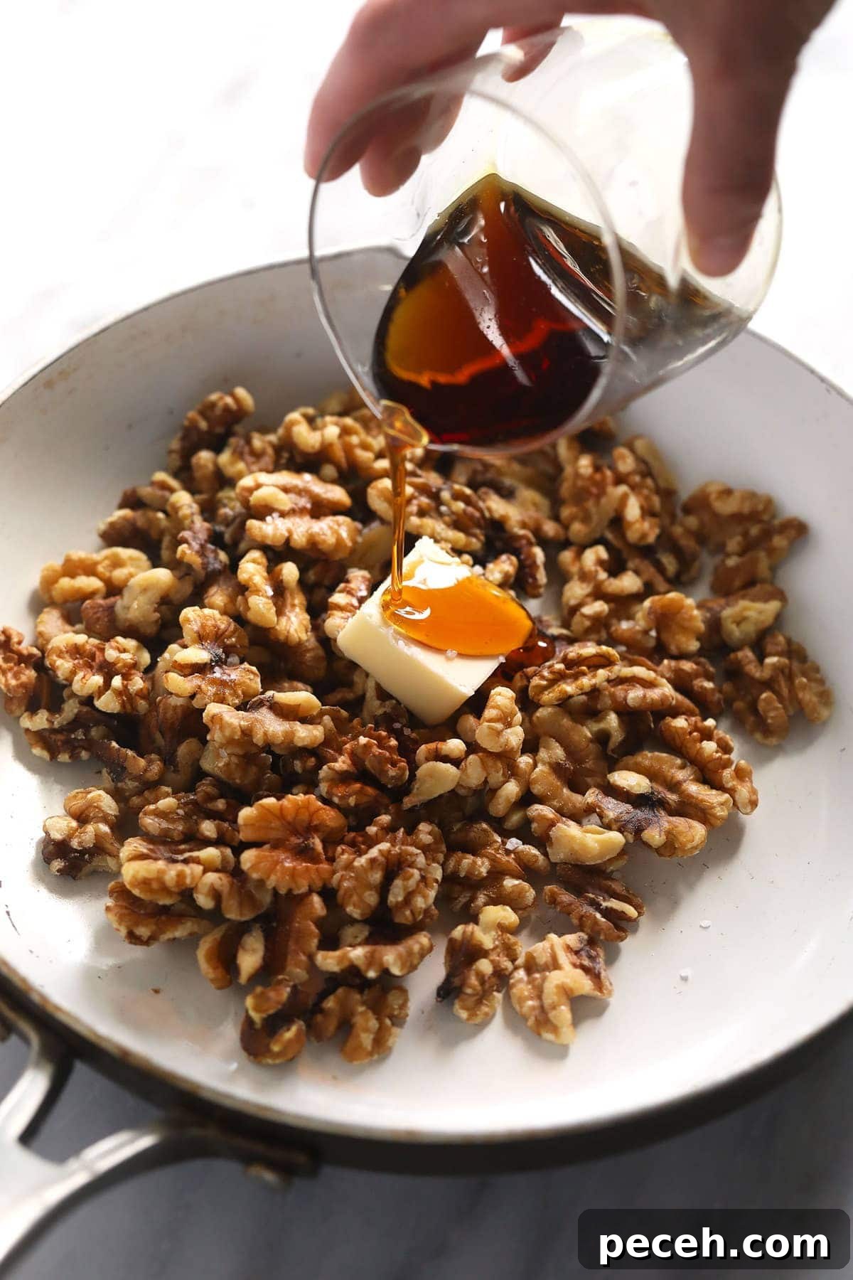 Candied Walnuts Recipe: Crunchy Sweet Coated Nuts in 20 Minutes 3 Pouring maple syrup in a pan.