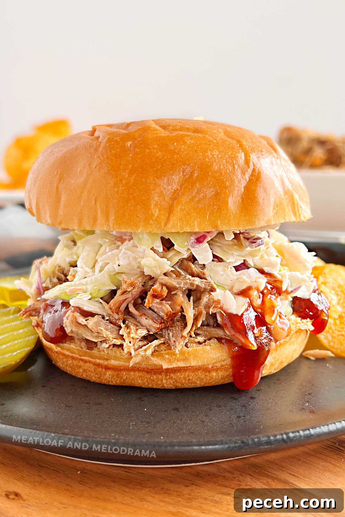 Tender Pulled Pork in the Instant Pot: Quick, Juicy Recipe 2 instant pot pulled pork sandwich with coleslaw and bbq sauce on a black plate