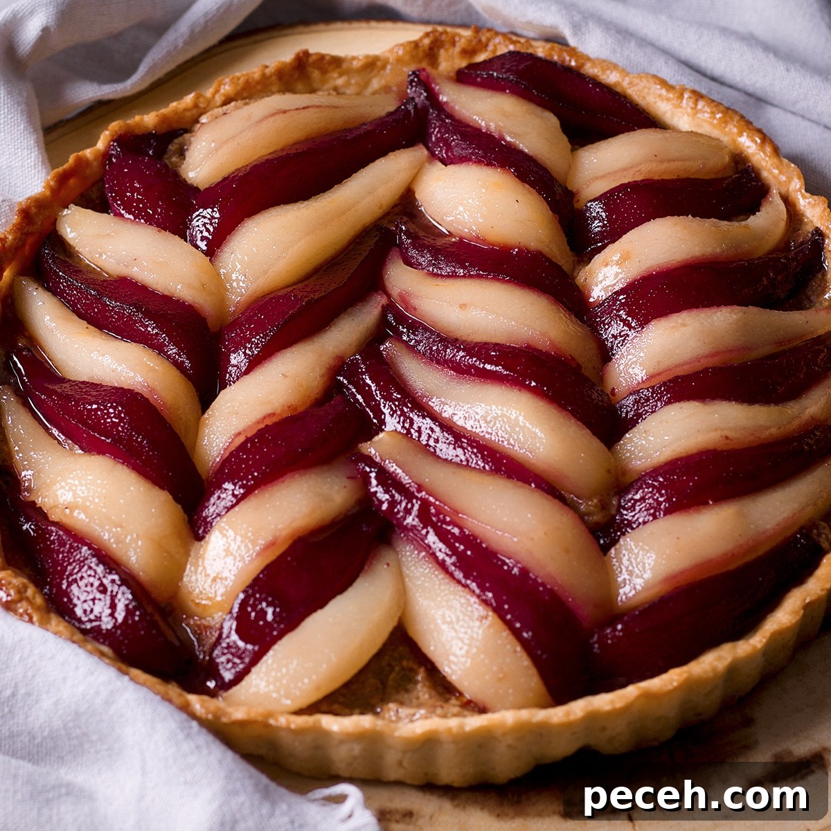 A pear and frangipane tart on a wood serving platter.