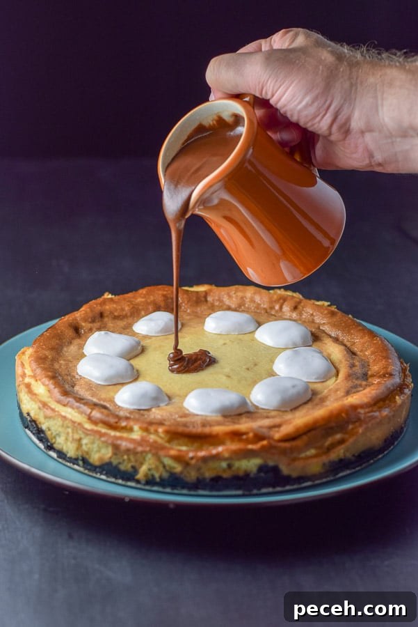 Decadent Rocky Road Cheesecake Recipe for Chocolate Lovers 7 Fluff dolloped on and ganache made and being poured onto the cheesecake