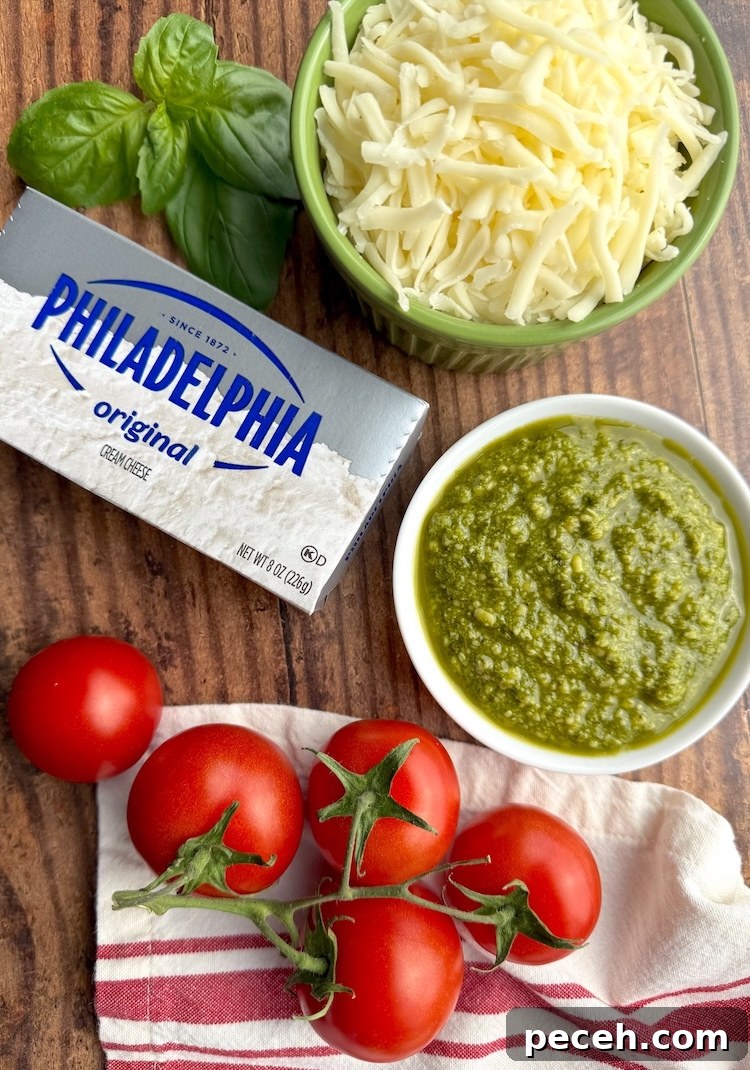 Creamy Pesto Baked Chicken Recipe with Garlic Parmesan Crust 3 List of ingredients need to make creamy pesto baked chicken including chicken breasts, cream cheese, basil pesto, mozzarella, fresh basil, and tomatoes.