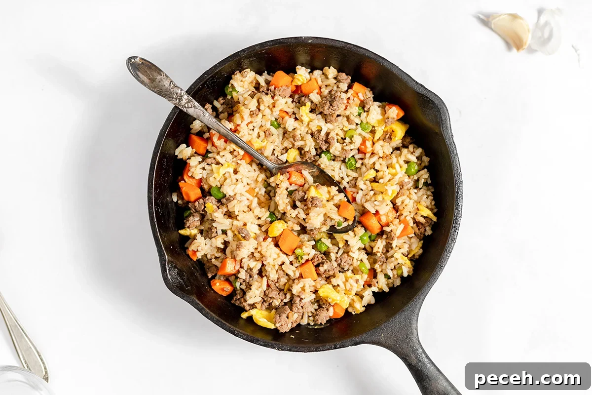 Ground Beef Fried Rice Recipe: Flavorful One-Pan Dinner 9 Cooked Ground Beef Fried Rice in cast iron skillet.