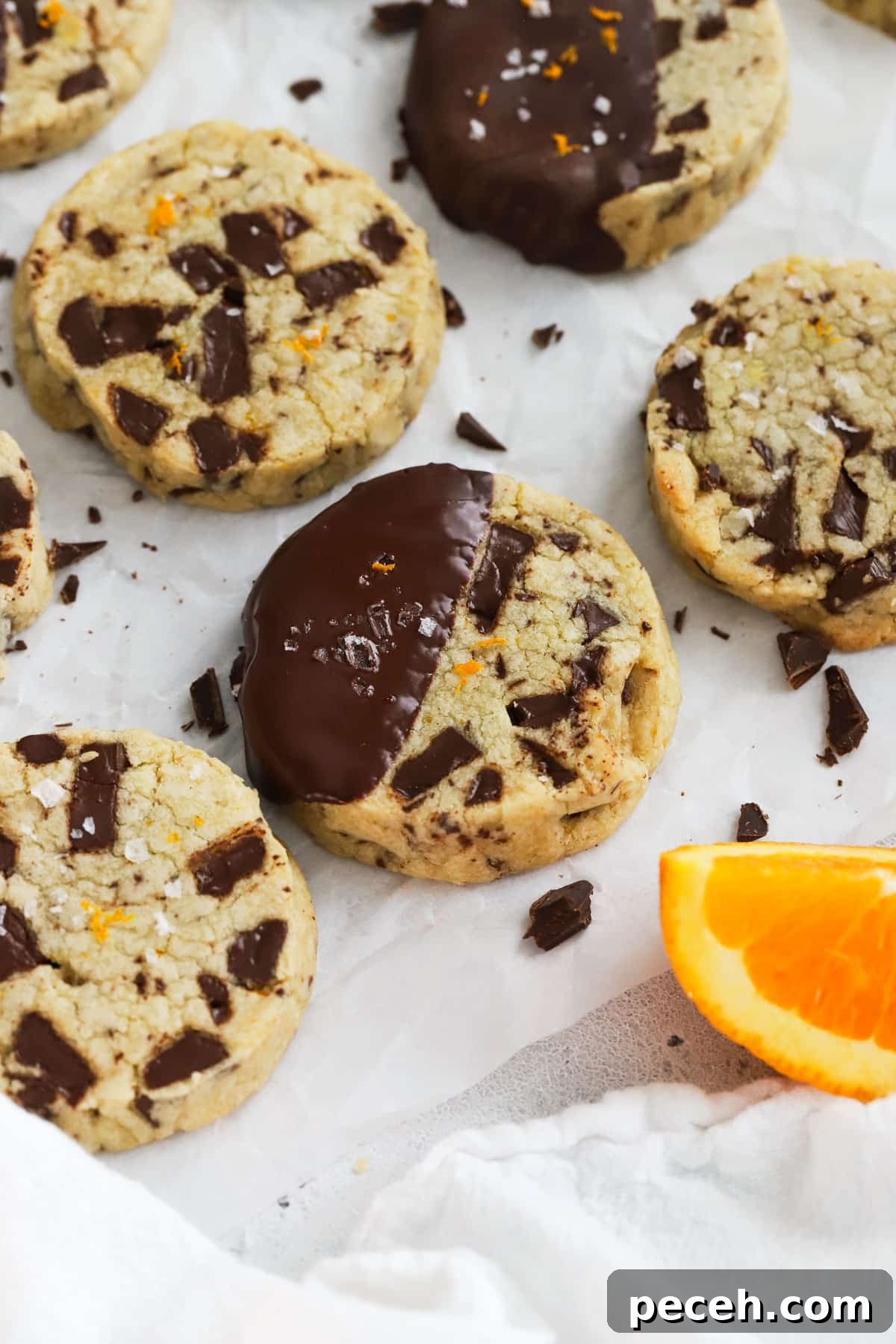 Orange Chocolate Chunk Shortbread Cookies (Gluten-Free) 2 gluten-free orange chocolate chunk shortbread cookies on parchment paper