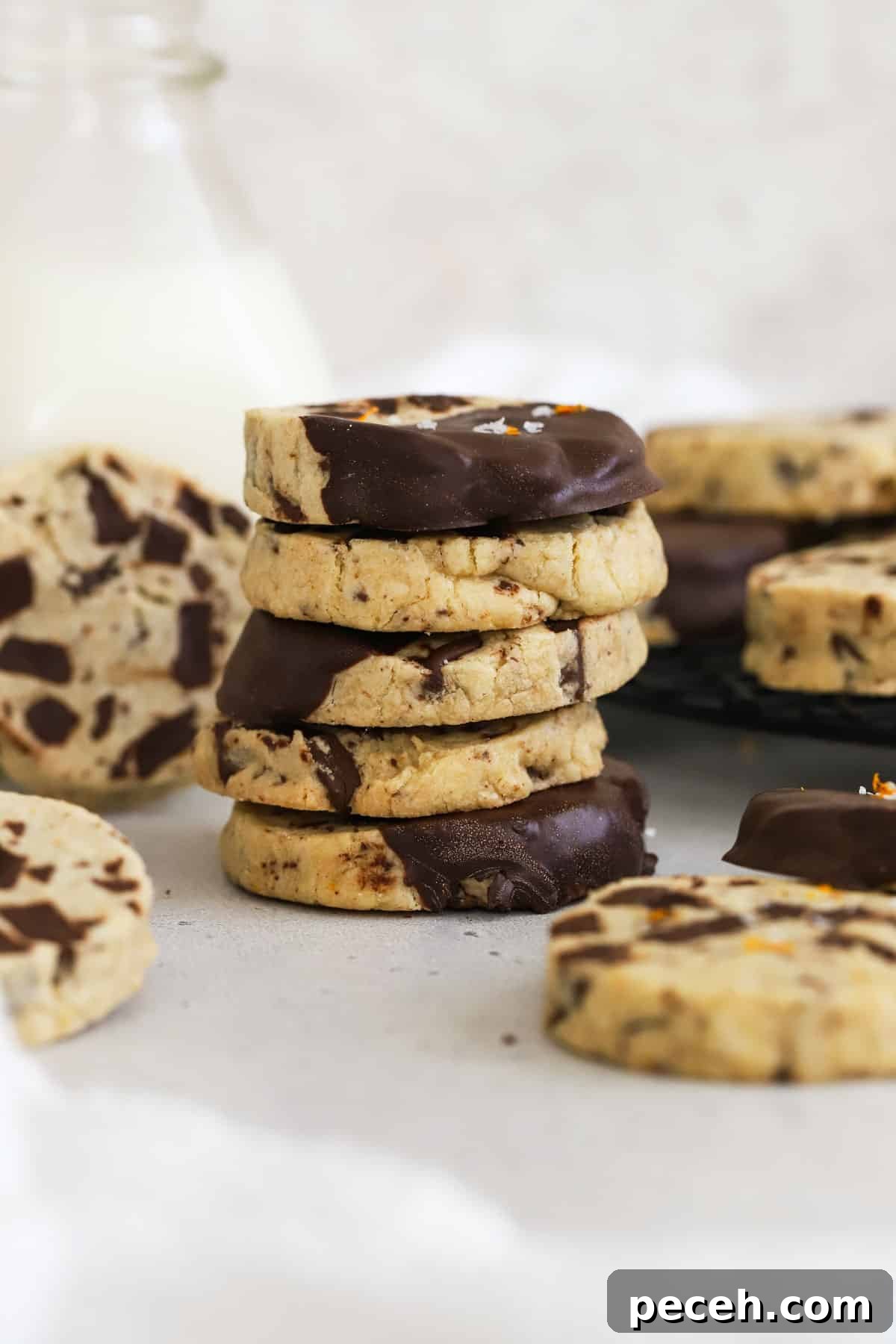 Orange Chocolate Chunk Shortbread Cookies (Gluten-Free) 7 gluten-free orange chocolate chunk shortbread cookies stacked next to a bottle of milk