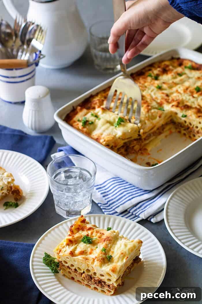 Classic Greek Pastitsio Recipe: Savory Baked Pasta Casserole 3 A shot of casserole being served from a casserole pan.