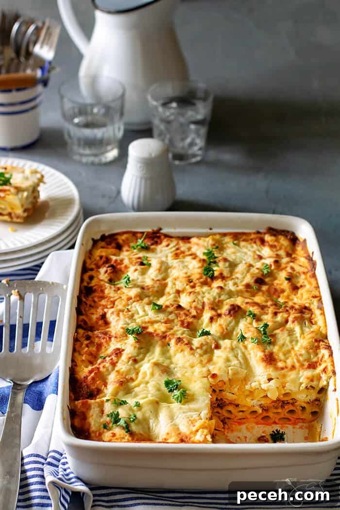 Classic Greek Pastitsio Recipe: Savory Baked Pasta Casserole 6 White casserole baking dish with Greek lasagna inside with one square serving removed