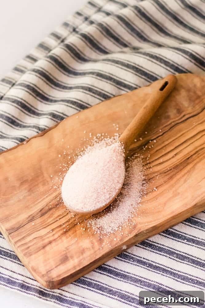 Himalayan Pink Salt Uses: 12 Practical Ways to Use It at Home 2 Pink Himalayan salt in wooden tablespoon on cutting board.