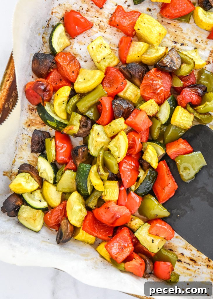 roasted veggies on a sheet pan with parchment paper.
