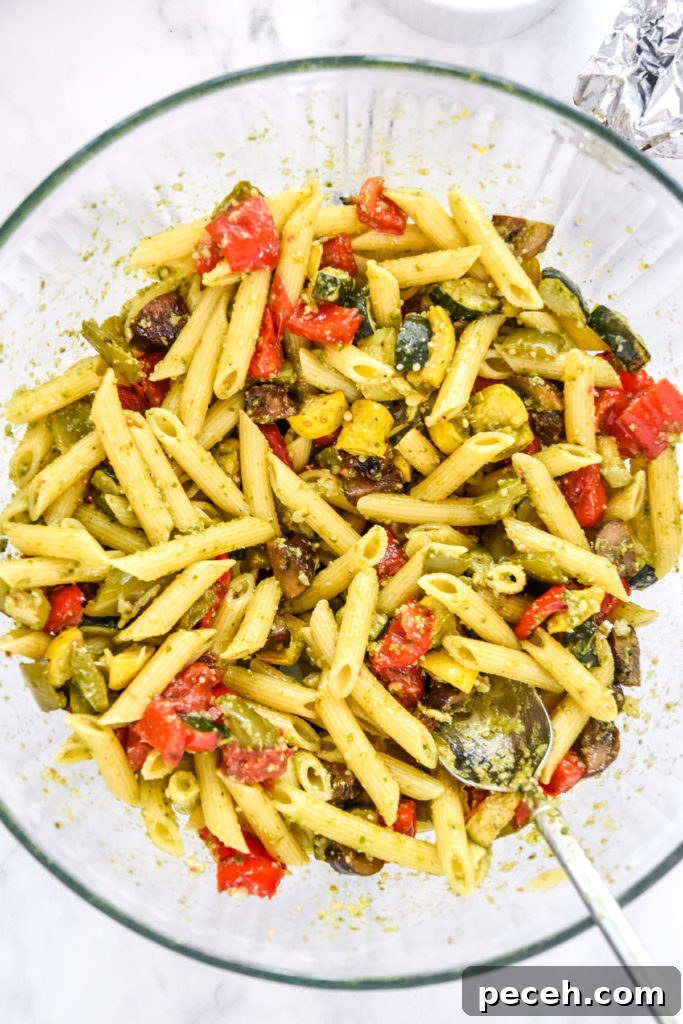 mixed roasted veggie pesto pasta in a large mixing bowl. 