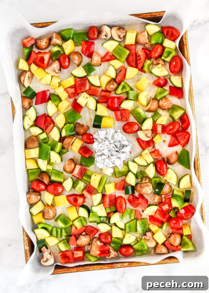 raw veggies on a baking pan with oil and salt before roasting.