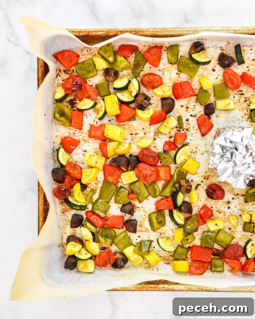 roasted veggies on a sheet pan with parchment paper.