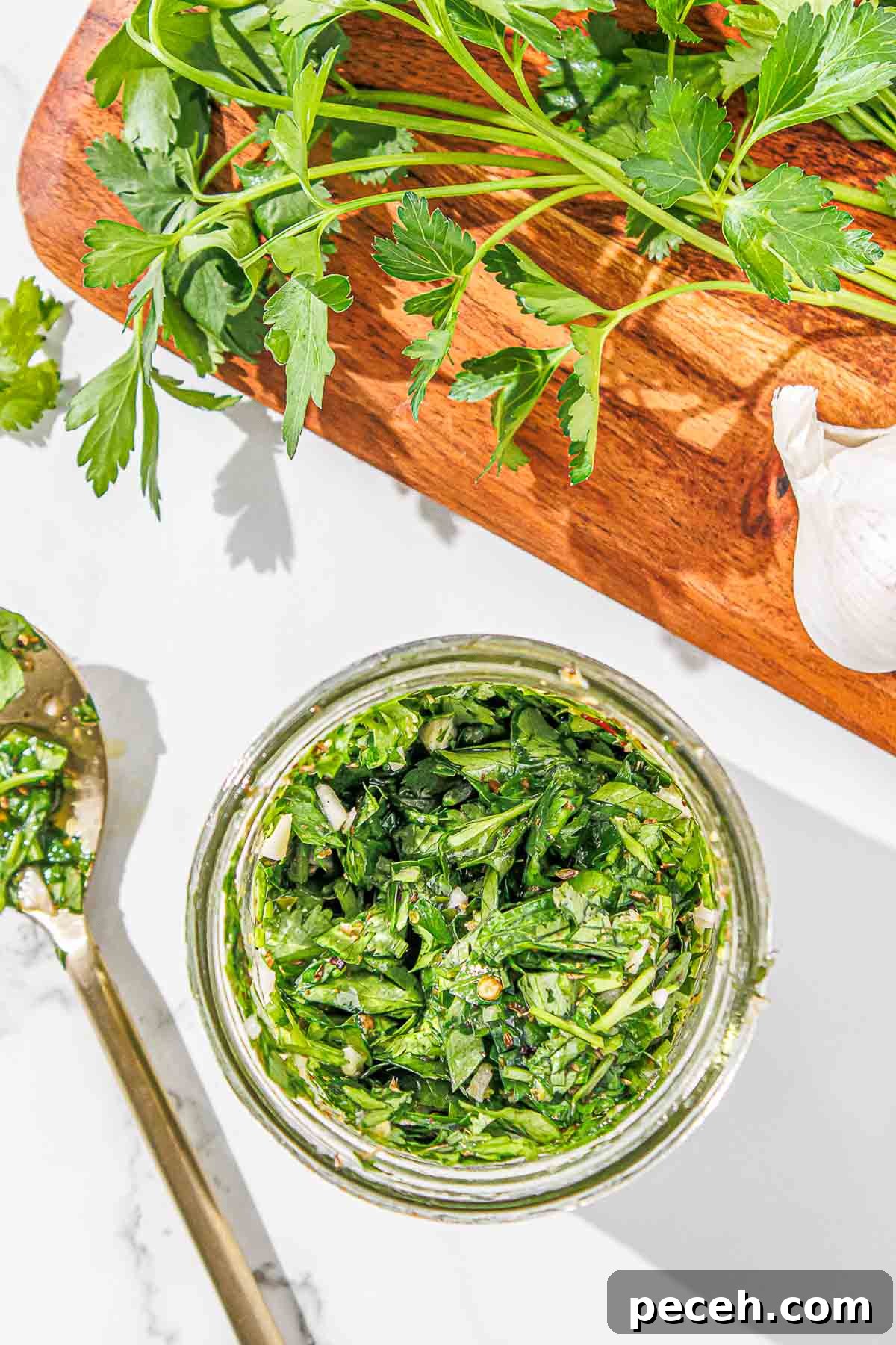 Cilantro Chimichurri Sauce: Zesty Recipe for Grilled Meats and Veggies 2 A jar of cilantro chimichurri on a wooden cutting board.