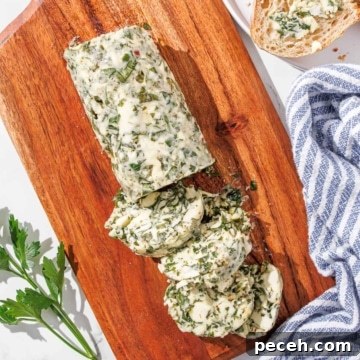 Sliced chimichurri butter on a wooden cutting board.
