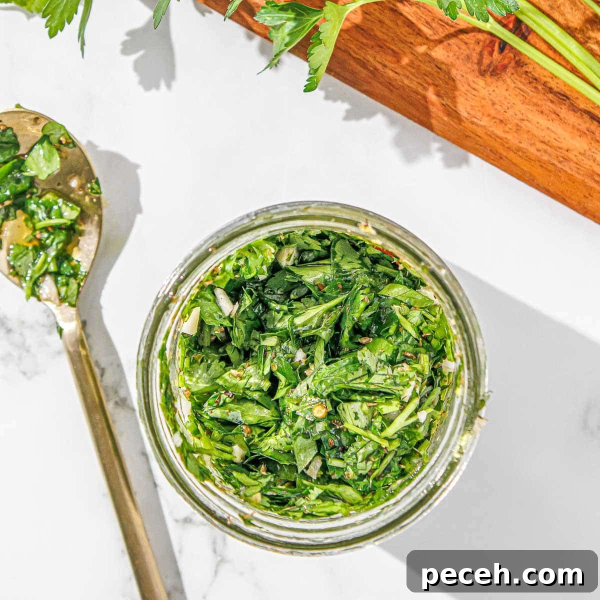 Cilantro Chimichurri Sauce: Zesty Recipe for Grilled Meats and Veggies 9 Cilantro chimichurri in a jar with a spoon.