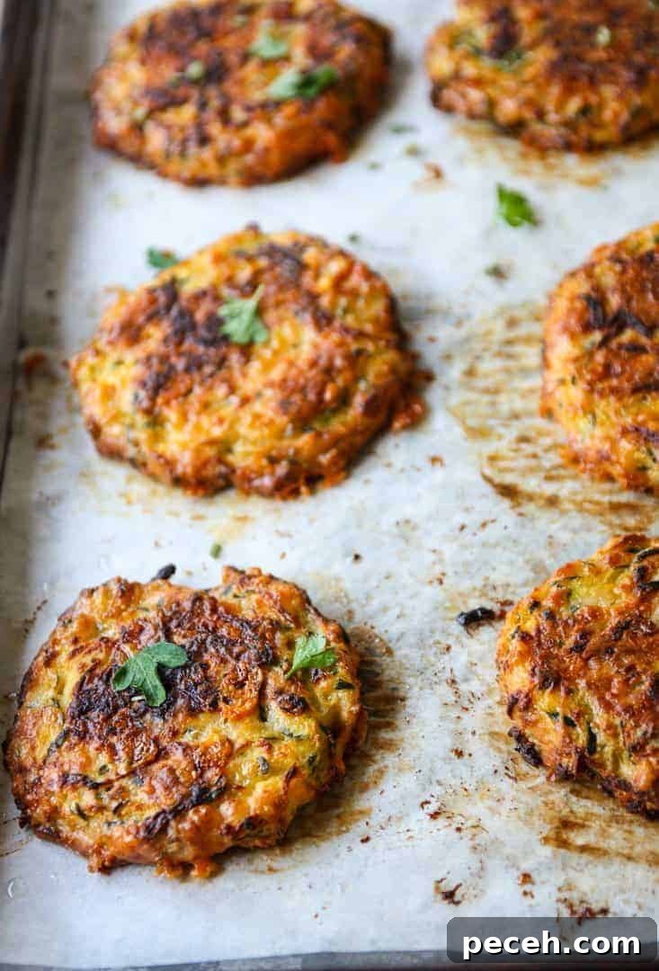 Gluten-Free Baked Zucchini Fritters Recipe 4 zucchini fritters on a baking sheet