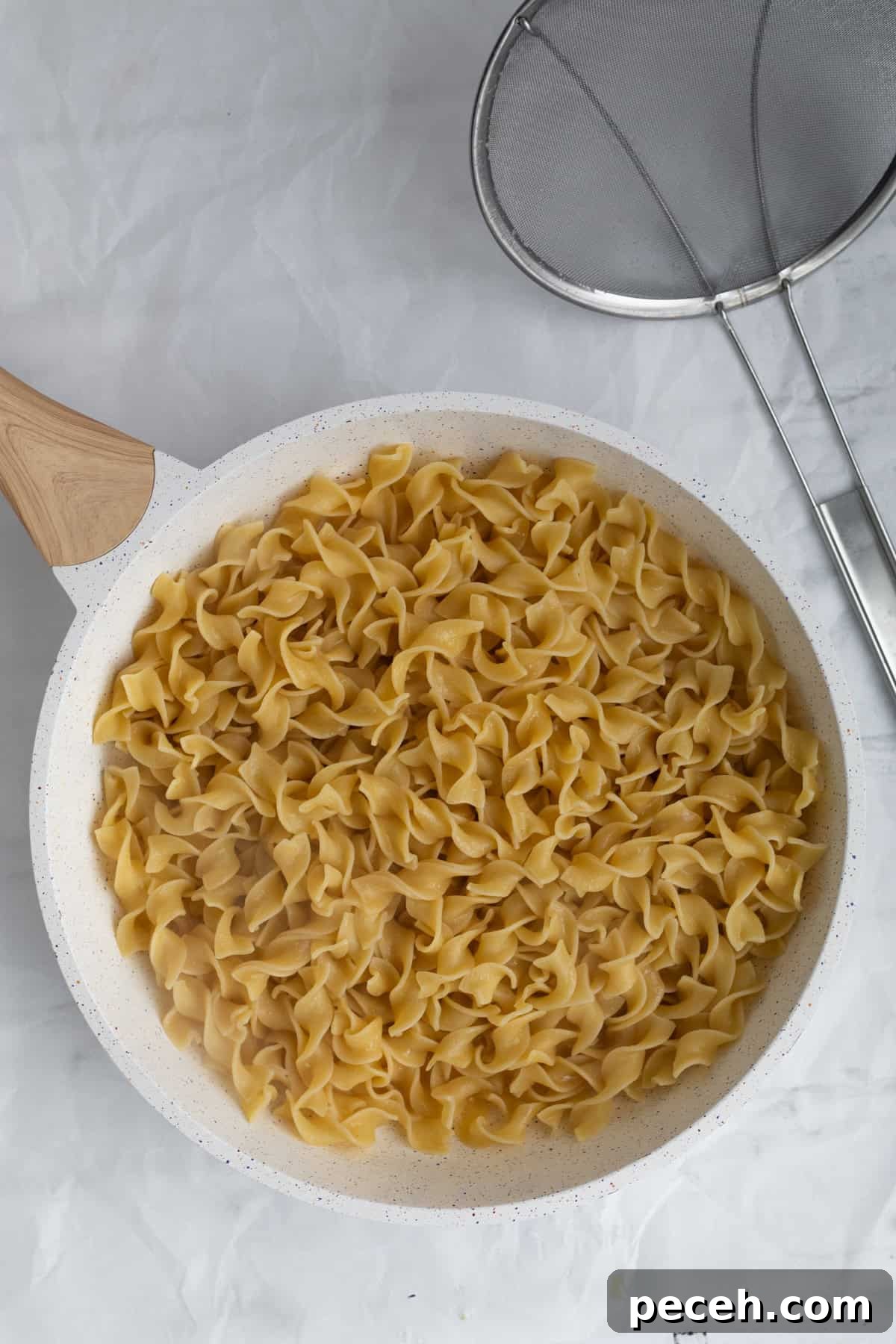 drained noodles added to the melted butter.