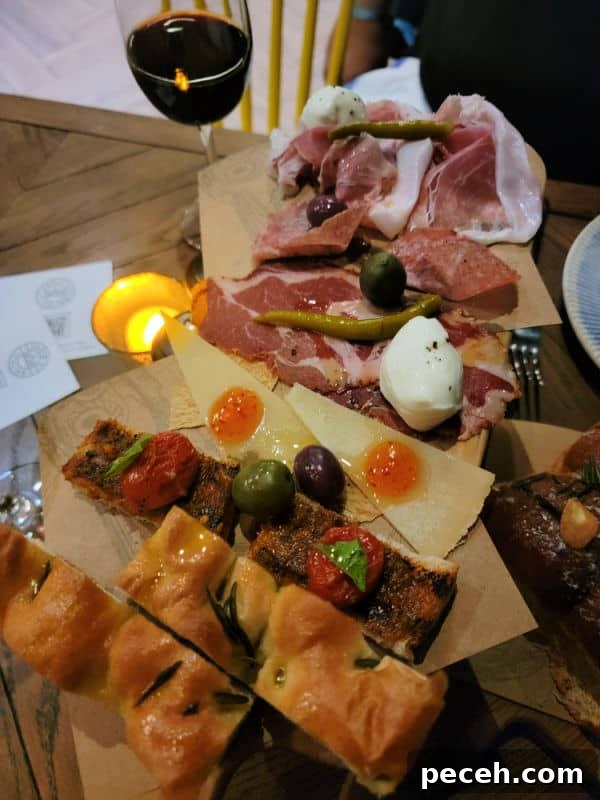 3-Night Royal Caribbean Navigator of the Seas Cruise to Ensenada 10 Glass of wine next to an antipasto platter with bread and meats.