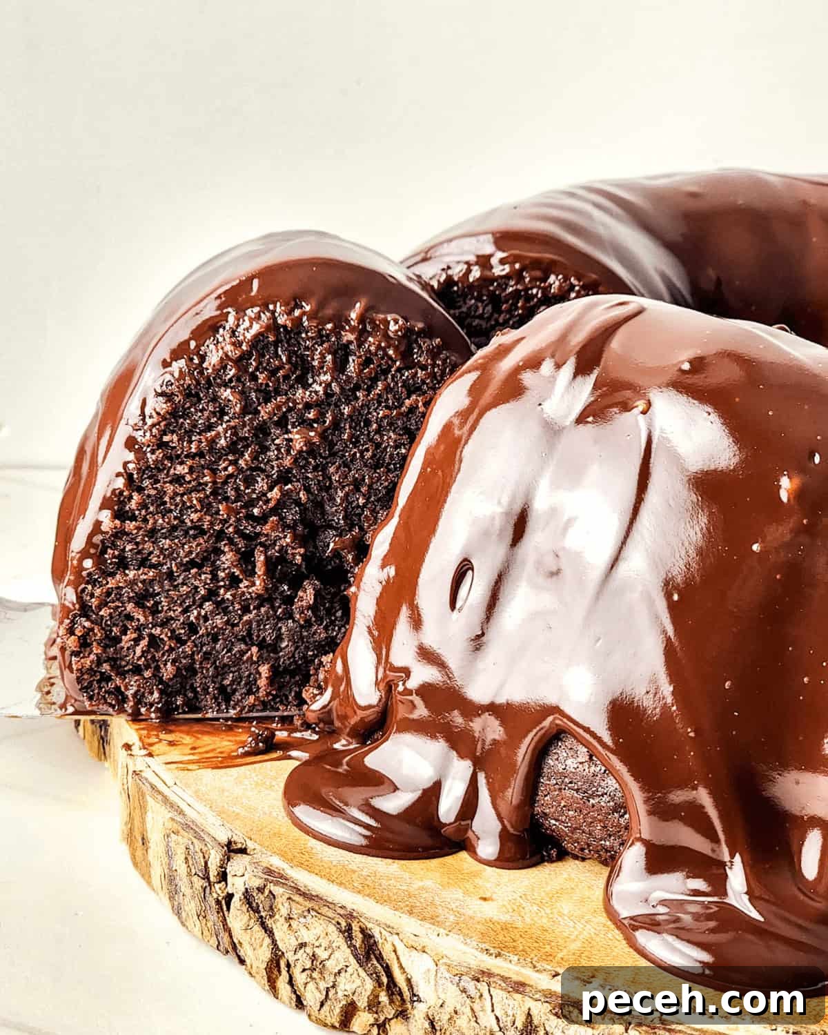 Moist Chocolate Chip Bundt Cake Recipe You’ll Love 3 Chocolate chip Bundt cakes with glossy ganache on a wooden serving board.