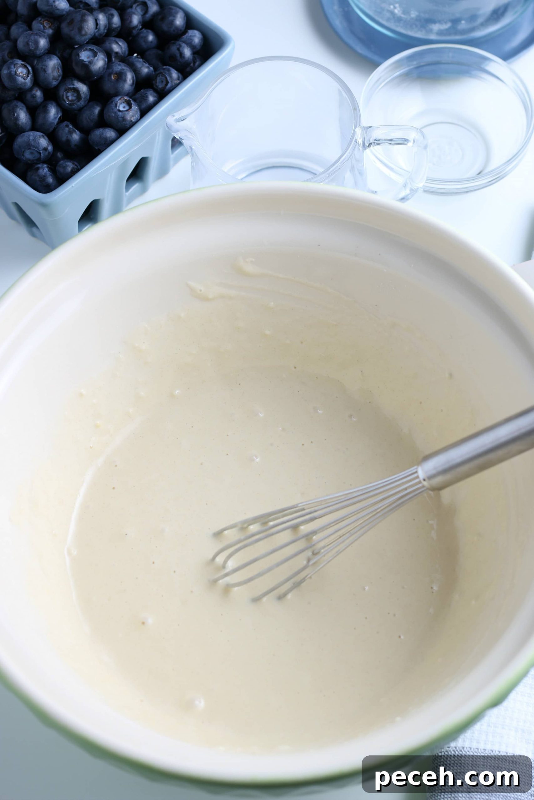 Homemade Blueberry Pancake Recipe for Fluffy, Perfect Stacks 5 mixed pancake batter in a white glass bowl