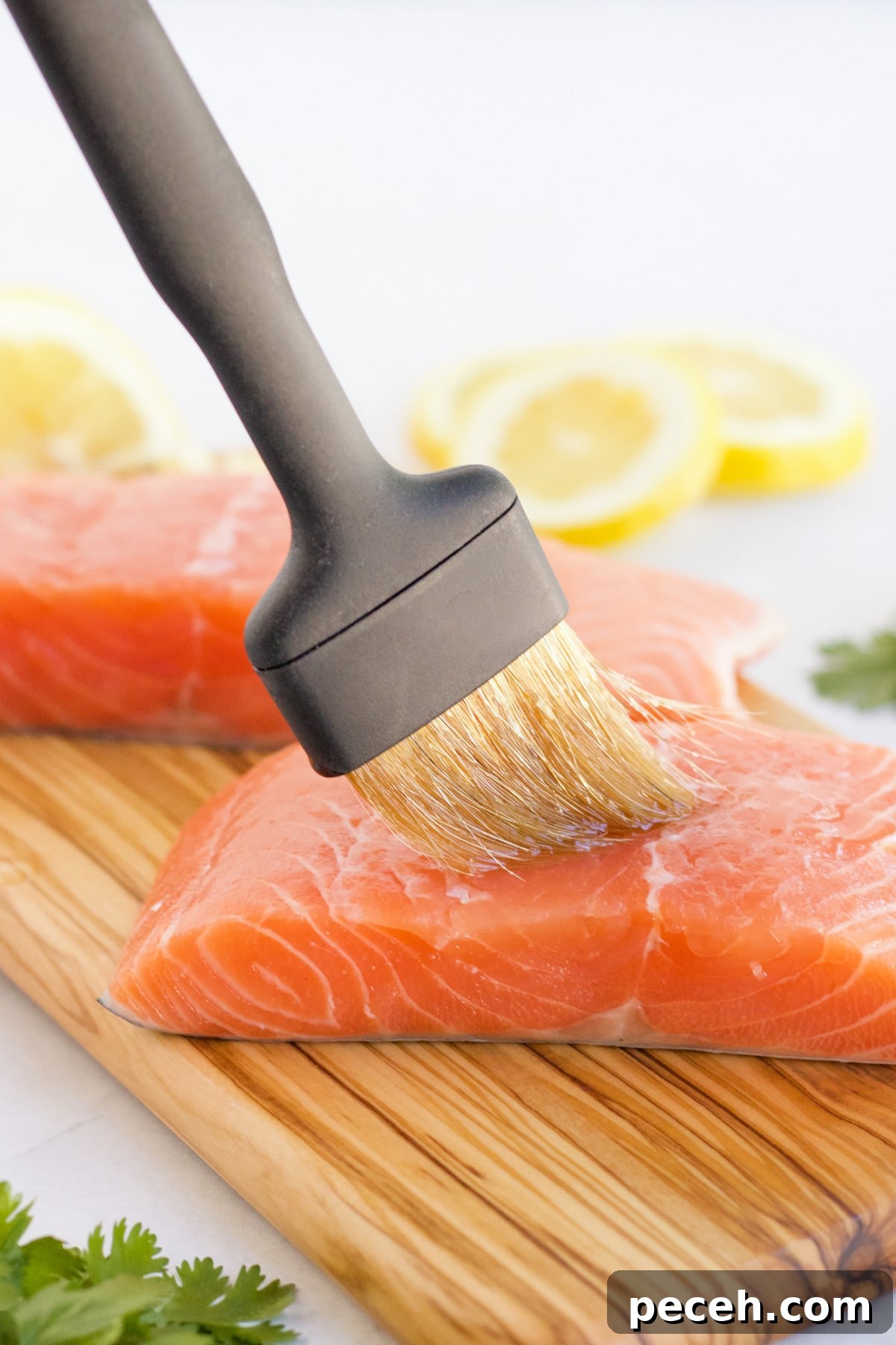 Perfectly Grilled Salmon with Crispy Skin and Lemon Herb Rub 4 Salmon being prepared for the grill by brushing olive oil on it.