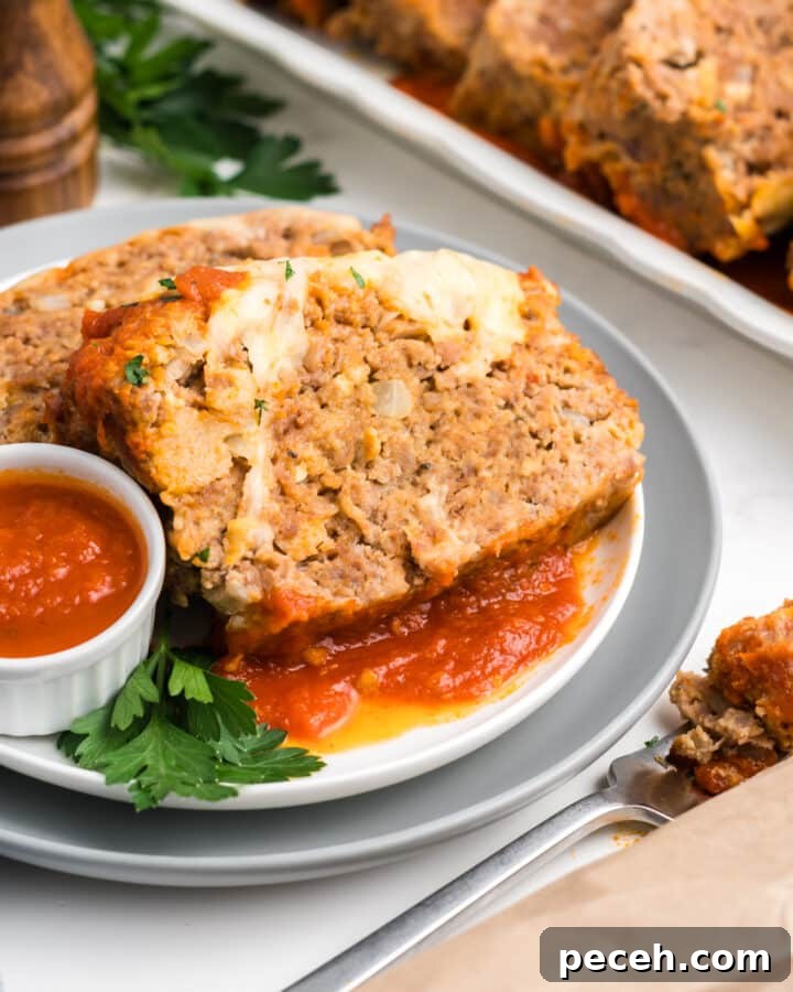 A plate of Italian meatloaf with a side of sauce.