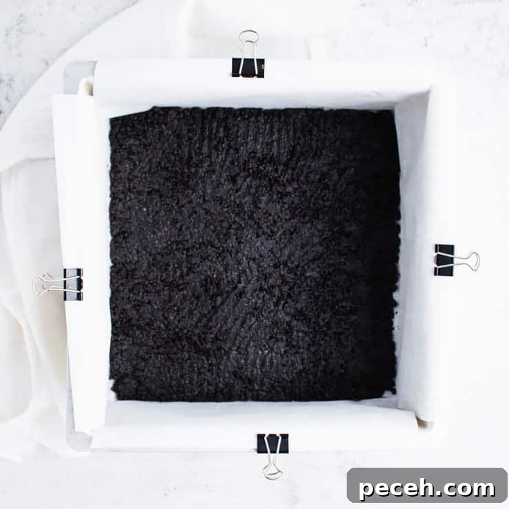 chocolate cookie crust pressed into a silver eight inch square cake pan.