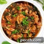 Ground chicken in a white dish with tomato sauce.