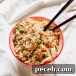 Chicken fried rice in red rimmed bowl.