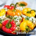 A cast iron pan full of ground chicken and herbs topped with bell pepper tops.