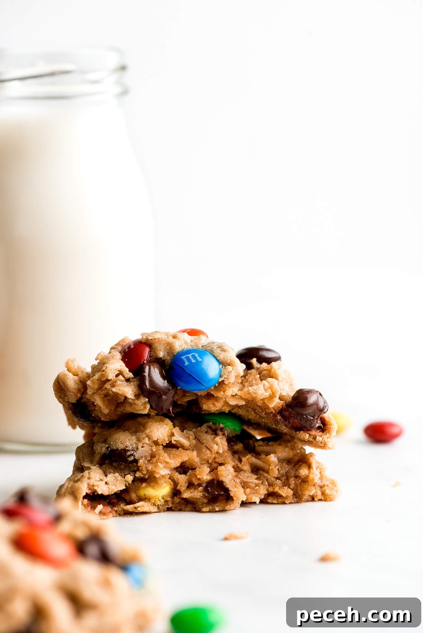Soft Chewy Monster Cookies Recipe – Loaded Chocolate Chip Cookies 3 Two halves of a cookie with m&m's and chocolate chips stacked on top of each other showing the chewy inside.