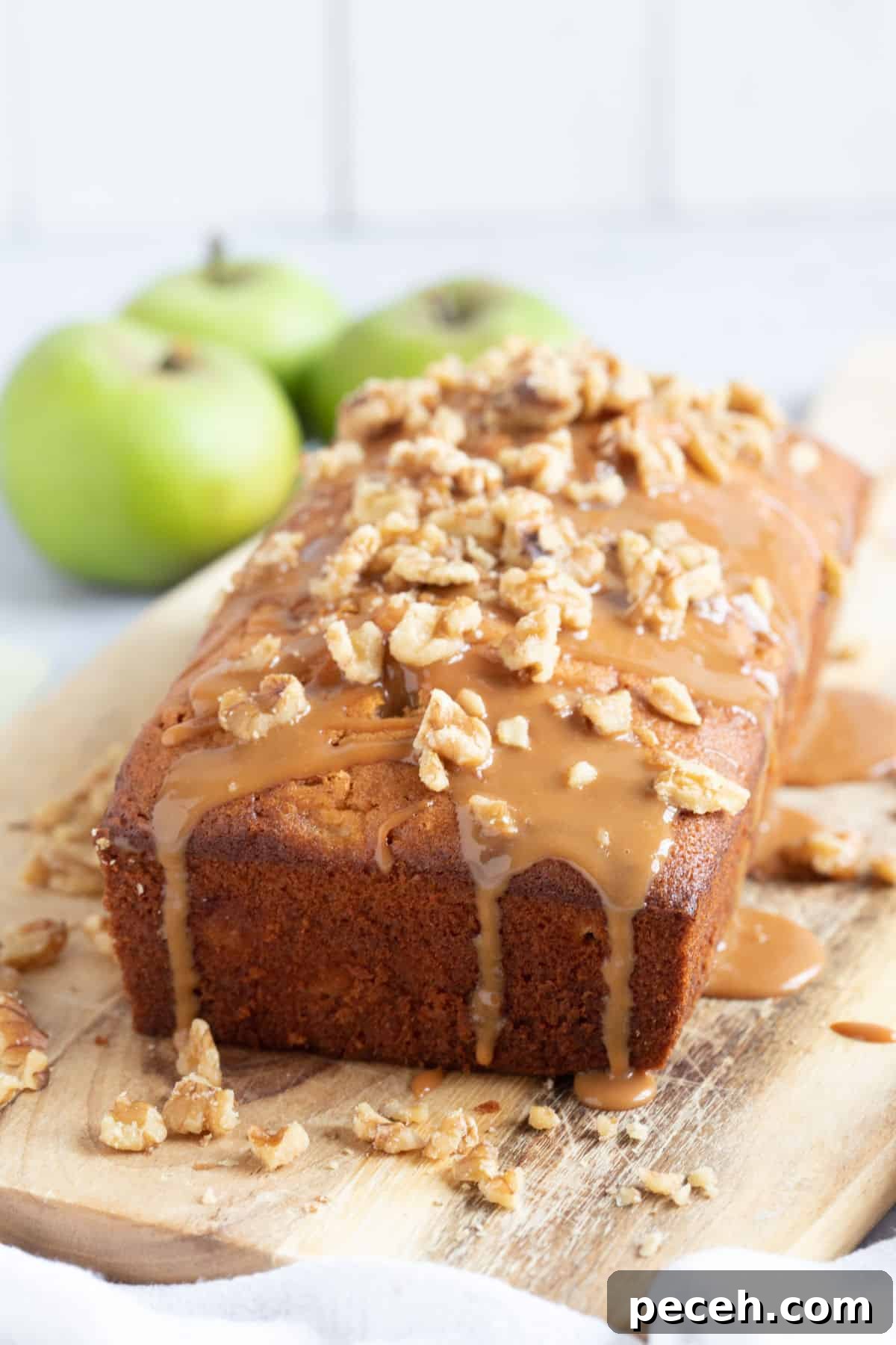 Moist Bramley Apple Loaf Cake Recipe — Tender Spiced Apple Loaf 5 Apple loaf cake on a wooden board.