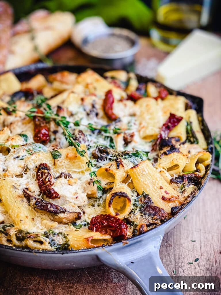 Creamy Chicken and Mushroom Rigatoni Recipe for Weeknights 3 pan full of creamy chicken pasta on a wooden cutting board