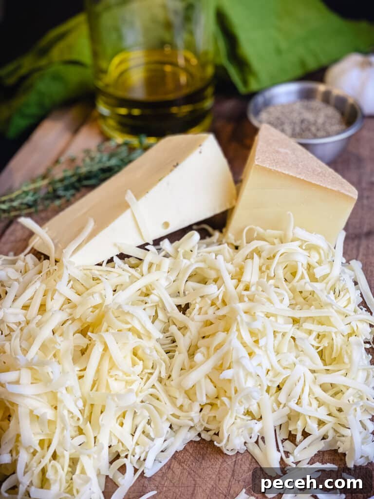 Creamy Chicken and Mushroom Rigatoni Recipe for Weeknights 4 shredded cheeses on a cutting board with olive oil and herbs