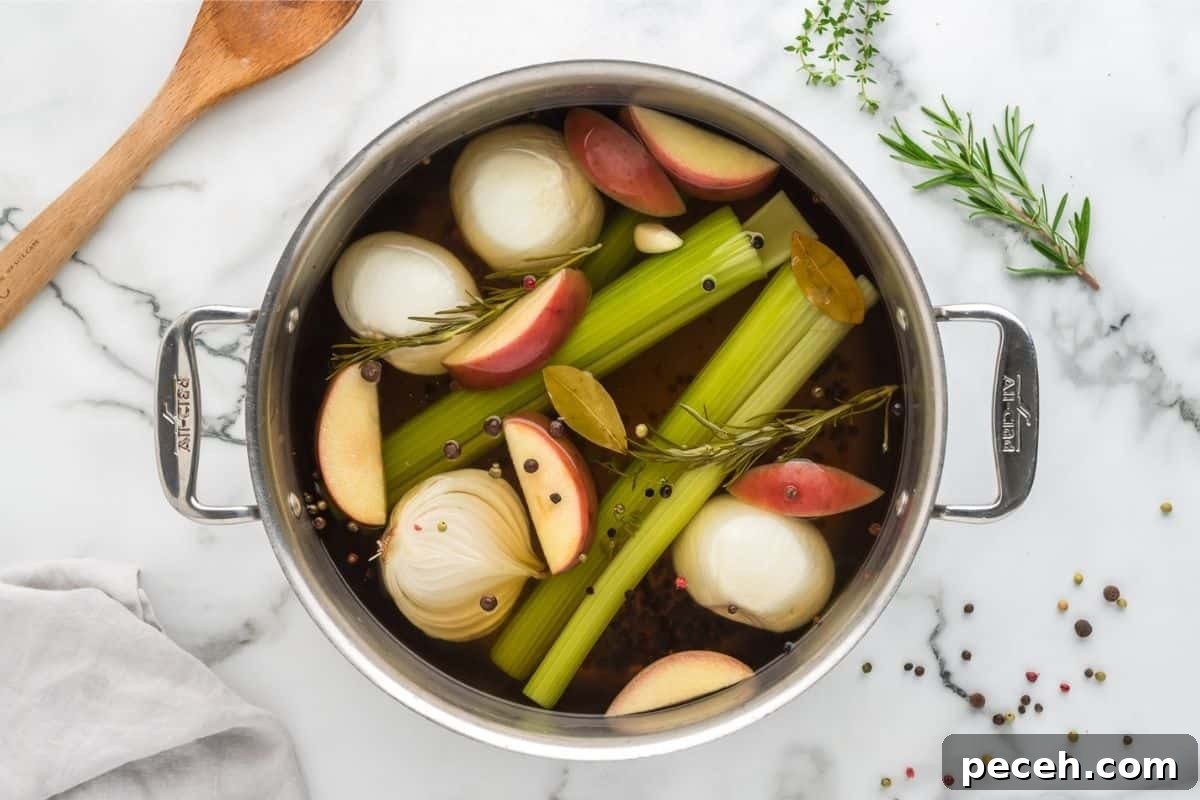 Cooked Turkey brine in large stock pan with apples, onions, peppercorns, onions, and celery in stock pan.