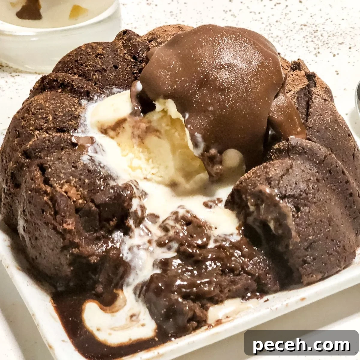 A plate with a chocolate molten lava cake with ice cream and homemade dairy free magic chocolate.