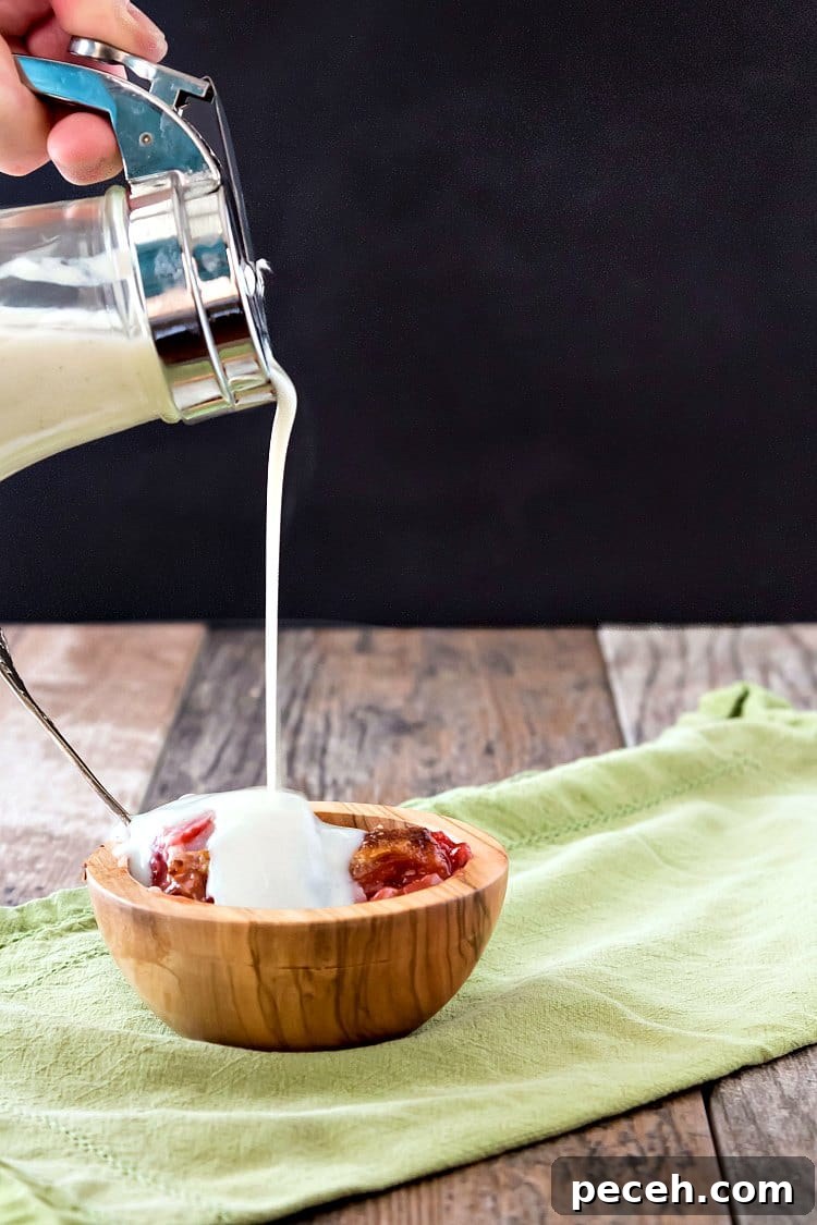 A pour shot of milk dip pouring over a wooden bowl of sonker.