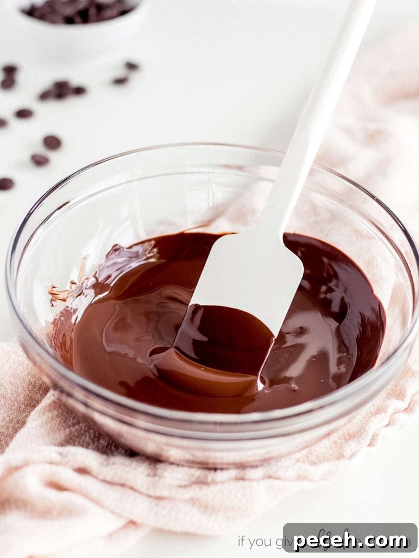 How to Melt Chocolate: Microwave and Stovetop Methods 6 silicone spatula in glass bowl of melted chocolate.