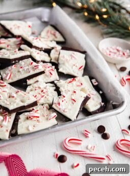 broken peppermint bark pieces piled on an aluminum baking tray