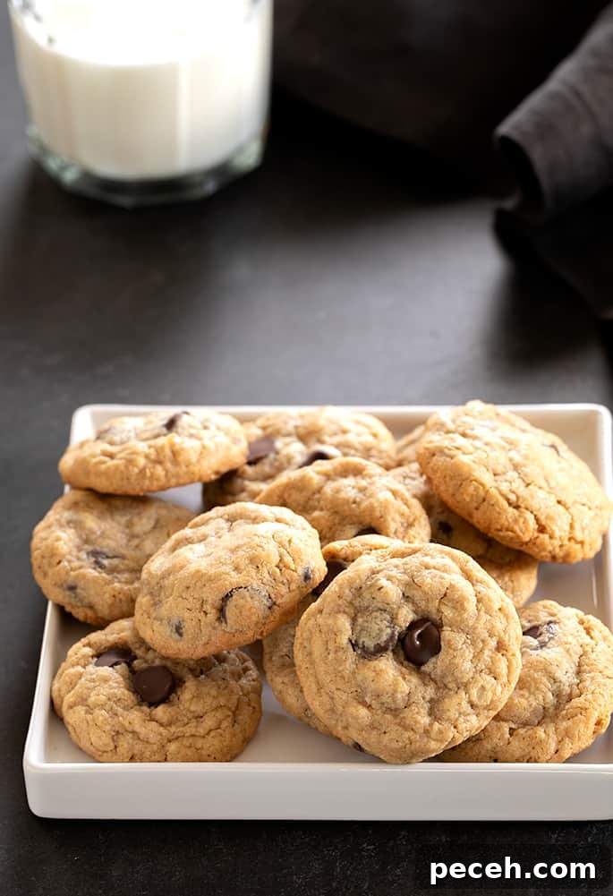A pile of peanut butter oatmeal chocolate chip cookies on a square white tray