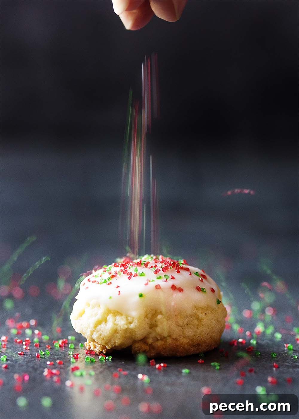 Sprinkles pouring onto a lemon ricotta cookie.