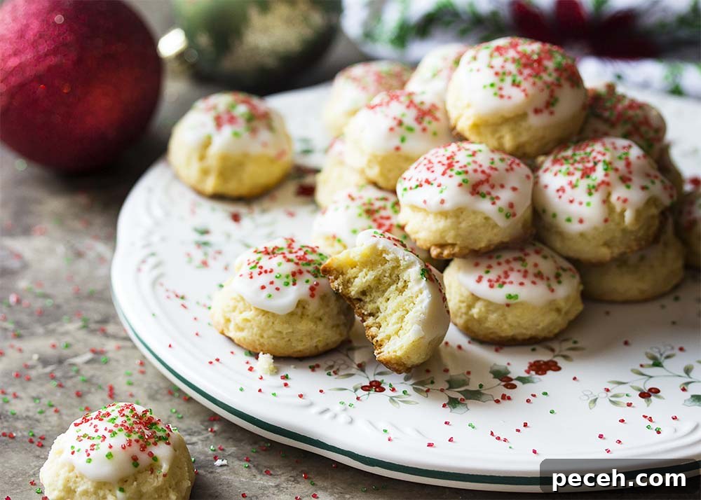 A plate piled with Italian cookies topped by lemon glaze and colorful sprinkles.