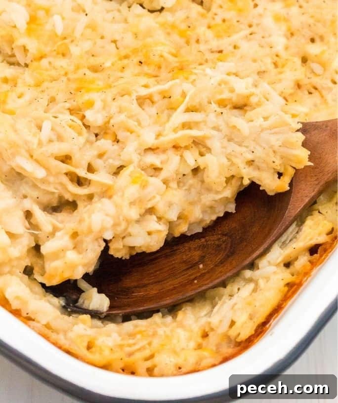 a pan of no-peek chicken and rice, with a wooden spoon scooping out a serving.