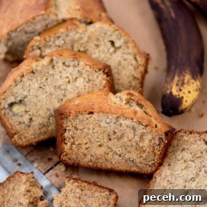 Classic Old-Fashioned Banana Bread Recipe for Perfect Loaf 6 Slices of banana bread on a wooden board, with a partially visible ripe banana in the background. The bread has a golden crust and a moist, speckled interior, and a knife is partially visible beside it.