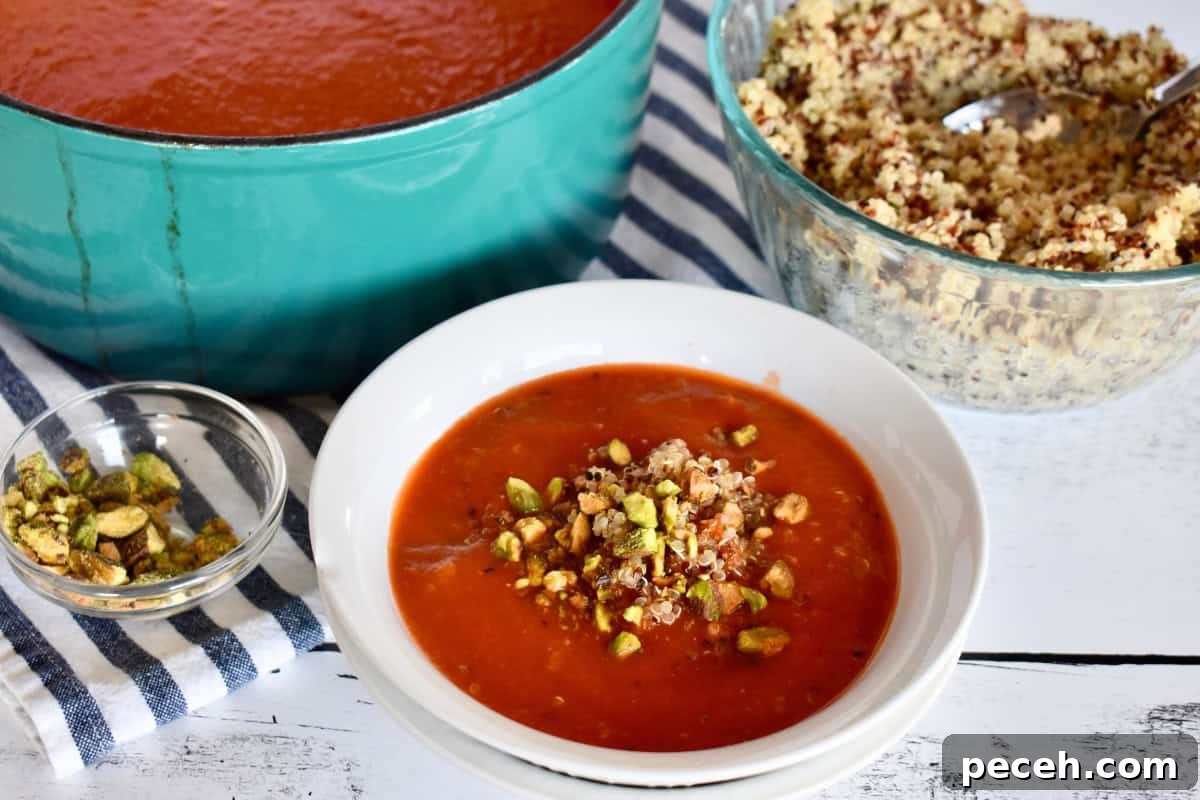 20-Minute Tomato Quinoa Soup Recipe for Weeknight Dinners 3 Tomato Quinoa Soup in a white bowl with chopped pistachios on top.