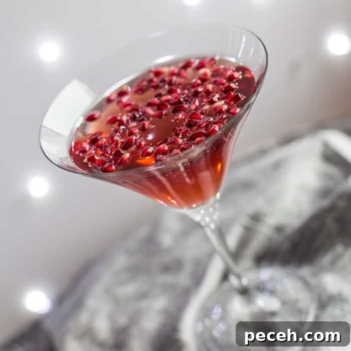 Romantic Date Night Dinner Recipes for Two 3 cocktail glass with pomegranate popper cocktail and pomegranate seeds against a sparkly grey background