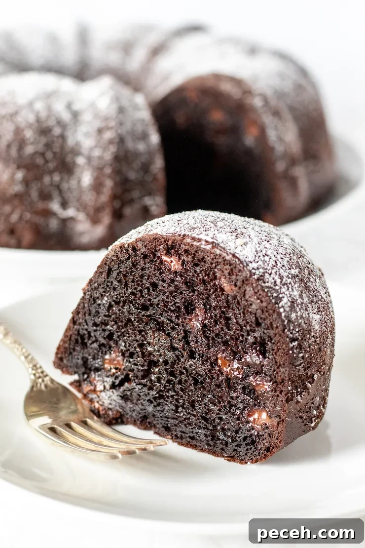 Piece of triple chocolate cake on plate with fork.